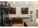 Modern kitchen with dark cabinetry, granite countertops, and stainless steel appliances at 2725 Morgan Glen Rd, Buford, GA 30519