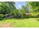Spacious backyard with mature trees, a deck, patio furniture, and manicured lawn at 3300 Wiltshire Dr, Avondale Estates, GA 30002
