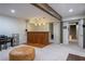 Finished basement with a wooden bar, carpeted floors and access to a stairwell at 3300 Wiltshire Dr, Avondale Estates, GA 30002