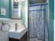 Compact bathroom with a unique vessel sink, wainscoting and a vibrant blue shower curtain at 3300 Wiltshire Dr, Avondale Estates, GA 30002