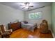 Cozy bedroom featuring hardwood floors, a crib, rocking chair, dresser, and a large window at 3300 Wiltshire Dr, Avondale Estates, GA 30002