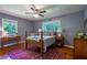 Spacious bedroom featuring hardwood floors, natural lighting, a ceiling fan, and windows with backyard views at 3300 Wiltshire Dr, Avondale Estates, GA 30002