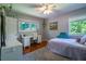 Cozy bedroom featuring hardwood floors, a ceiling fan, and a bright window view at 3300 Wiltshire Dr, Avondale Estates, GA 30002