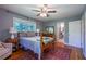 Comfortable bedroom featuring hardwood floors, natural lighting, a ceiling fan, and connected bathroom at 3300 Wiltshire Dr, Avondale Estates, GA 30002