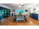Dining room with hardwood floors, ceiling fan, access to sunroom, modern table and chair set, and large window at 3300 Wiltshire Dr, Avondale Estates, GA 30002