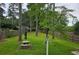 This backyard features a stone picnic table, bird feeder, mature trees, and fenced perimeter at 529 Valley Woods Se Cir, Conyers, GA 30094