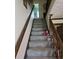 Carpeted stairs with stained wood railing and trim lead to the upper level at 529 Valley Woods Se Cir, Conyers, GA 30094