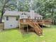Backyard view of the deck with stairs leading down to a large grassy area at 250 Daileys Plantation Dr, Mcdonough, GA 30253