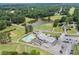 Aerial view of a community clubhouse featuring a pool, parking, and a scenic pond at 705 Clubhouse Se Dr, Conyers, GA 30094