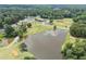 Scenic aerial view of a community with a pond, golf course, tennis courts and clubhouse at 705 Clubhouse Se Dr, Conyers, GA 30094