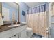 Bathroom with a vanity and matching mirror next to a toilet and bathtub with shower curtain at 705 Clubhouse Se Dr, Conyers, GA 30094
