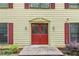 Close up of the front door, with red shutters on a yellow house and landscaping at 705 Clubhouse Se Dr, Conyers, GA 30094