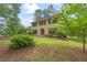 Exterior front view of a yellow home with mature trees and landscaping surrounding the property at 705 Clubhouse Se Dr, Conyers, GA 30094