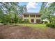 Charming yellow two-story home with red shutters and a well-manicured front yard surrounded by mature trees at 705 Clubhouse Se Dr, Conyers, GA 30094