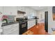 Kitchen showcases white cabinets, black appliances, wood floors, a brick backsplash, and ample counter space at 705 Clubhouse Se Dr, Conyers, GA 30094