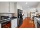 Bright kitchen featuring white cabinets, black appliances, brick backsplash, hardwood floors, and recessed lighting at 705 Clubhouse Se Dr, Conyers, GA 30094