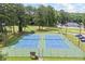 Aerial view of well-maintained blue and green tennis courts surrounded by mature trees at 705 Clubhouse Se Dr, Conyers, GA 30094