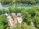 Aerial view of a lakeside property with a circular driveway, green space, mature trees, and lake access at 6900 Driskell Cir, Cumming, GA 30041