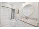 Clean bathroom featuring a tub with shower, white vanity, round mirror, and modern commode at 6900 Driskell Cir, Cumming, GA 30041