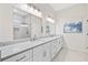 Bright bathroom with double sink vanity, modern faucets, stone countertops, and frameless glass shower at 6900 Driskell Cir, Cumming, GA 30041