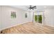 Neutral bedroom with hardwood floors, a ceiling fan, two windows and sliding glass door to balcony at 6900 Driskell Cir, Cumming, GA 30041