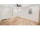 Minimalist bedroom with hardwood floors, a ceiling fan, two windows, and a walk-in closet at 6900 Driskell Cir, Cumming, GA 30041