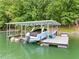 Covered boat dock on the lake featuring a boat, jet ski, and storage, perfect for waterside fun at 6900 Driskell Cir, Cumming, GA 30041