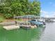 Lakefront boat dock with a covered area, boat lift, jet ski, and ample space for aquatic activities at 6900 Driskell Cir, Cumming, GA 30041