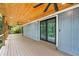 Covered deck featuring a wood plank ceiling, ceiling fan, and wooded views at 6900 Driskell Cir, Cumming, GA 30041