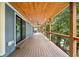 Spacious wooden deck featuring a wood plank ceiling, ceiling fan, and scenic views at 6900 Driskell Cir, Cumming, GA 30041