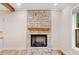 Elegant stone fireplace with a wooden mantel and gas insert, the focal point of a cozy living space at 6900 Driskell Cir, Cumming, GA 30041