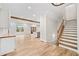 Open-concept living area with natural light, hardwood floors, wooden beam, and staircase to upper level at 6900 Driskell Cir, Cumming, GA 30041
