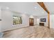 Bright living room with wood beam, a window overlooking the yard, and wood-look floors at 6900 Driskell Cir, Cumming, GA 30041