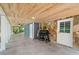 Covered patio features stone accent wall, tile floor, and outdoor grill for entertaining at 6900 Driskell Cir, Cumming, GA 30041