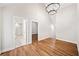 An upstairs room with wood floors, large chandelier, high ceilings and an open doorway to a tiled bathroom at 6900 Driskell Cir, Cumming, GA 30041