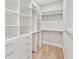 Large walk-in closet with custom shelving, drawers, and hanging rods for organization at 6900 Driskell Cir, Cumming, GA 30041