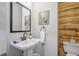 Stylish bathroom featuring wood accent wall, a modern sink, and a sleek mirror, adding a touch of elegance at 1244 Harris Commons Pl, Roswell, GA 30076