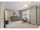 Spacious bedroom featuring neutral walls, carpet flooring, ceiling fan, and a comfortable sitting area near the window at 1244 Harris Commons Pl, Roswell, GA 30076