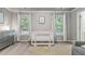Bedroom displaying a crib, complemented by a dresser and large windows that let in ample natural light at 1244 Harris Commons Pl, Roswell, GA 30076
