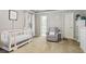 Bedroom showcasing a crib and comfortable chair, designed with soft colors and calming decor, creating a cozy ambiance at 1244 Harris Commons Pl, Roswell, GA 30076