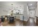 Open dining area with modern lighting and kitchen view; showcases hardwood floors, access to staircase and front door at 1244 Harris Commons Pl, Roswell, GA 30076