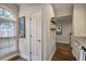 Hallway featuring natural light from arched window, access to staircase, and neutral paint scheme, creating a bright and airy space at 1244 Harris Commons Pl, Roswell, GA 30076