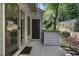 Back patio featuring a sliding glass door, privacy fence, landscaping, and outdoor lighting creating a pleasant space at 1244 Harris Commons Pl, Roswell, GA 30076