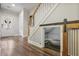 Under-stair nook, featuring hardwood floors, barn-door, and access to front door, offering storage space at 1244 Harris Commons Pl, Roswell, GA 30076