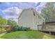 A view of the backyard with a two-story home, small deck, and green grass at 3781 Deercreek Dr, Powder Springs, GA 30127