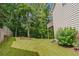 Backyard featuring a lush lawn, mature trees, planting bed, and deck with stairs at 3781 Deercreek Dr, Powder Springs, GA 30127
