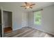Bright bedroom features wood-look floors, a ceiling fan, and a window that offers abundant natural light at 3781 Deercreek Dr, Powder Springs, GA 30127