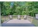 Relaxing outdoor deck featuring three chairs and overlooks a private wooded backyard at 3781 Deercreek Dr, Powder Springs, GA 30127