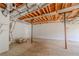 Unfinished basement showing exposed ceiling with a door and shelving along the wall at 3781 Deercreek Dr, Powder Springs, GA 30127
