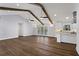 Open floor plan with hardwood floors, wood beams, view to kitchen, and access to the outdoor patio at 4178 Castle Pines Ct, Tucker, GA 30084